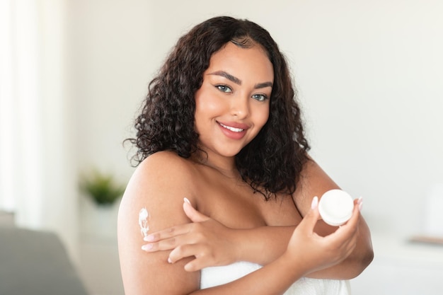 Fresh skin moisturizing and nutrition for body Positive african american plus size lady using cream for skin