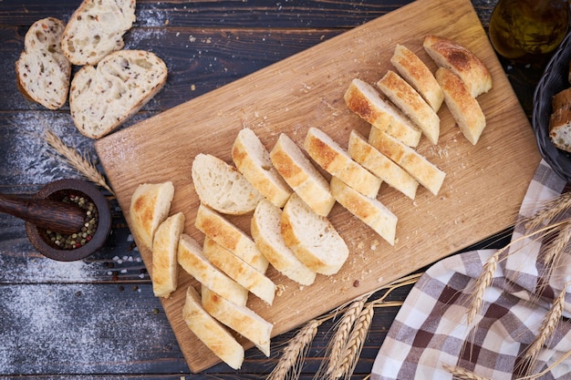 Fresh sliced bread on wooden cutting board at kitchen table