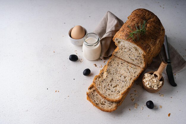 Photo fresh sliced homemade wholegrain wheat bread whit olive oil on white rustic background