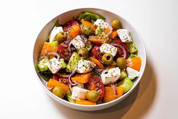 Fresh sliced vegetables for salad in a plate on a white background