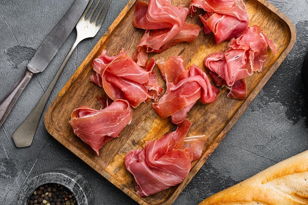 Fresh slices jamon set on gray stone table background top view flat lay