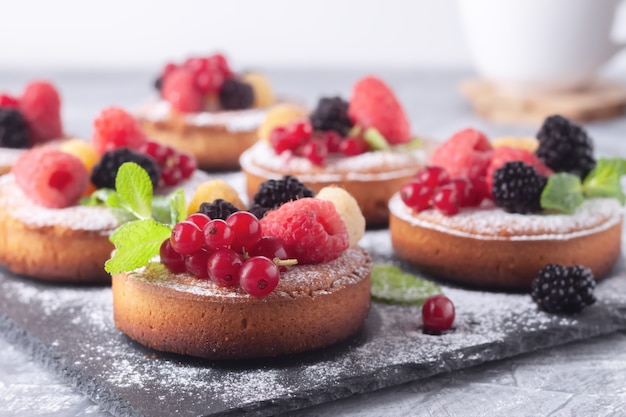 Fresh small homemade fruit pies with raspberries, currants and blackberries on the table