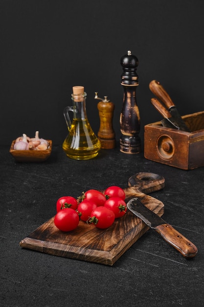 Fresh small whole tomatoes on wooden cutting board