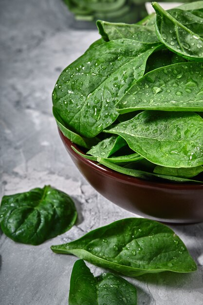 Fresh spinach in an old bowl on a gray