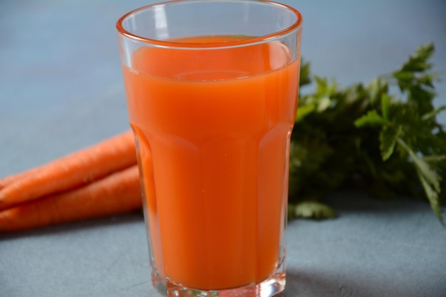 Fresh squeezed carrot juice in a Glass with carrots on a table Healthy eating detox dieting and vegetarian concept