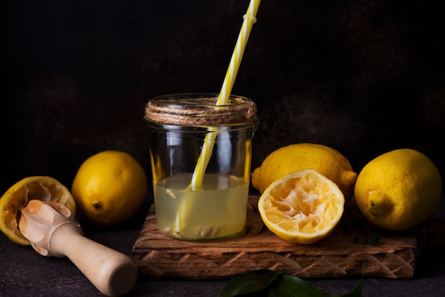 Fresh squeezed juice from lemon halves with a juicer in a glass jar, selective focus