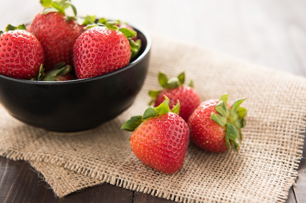 Fresh strawberries in a bowl on wood