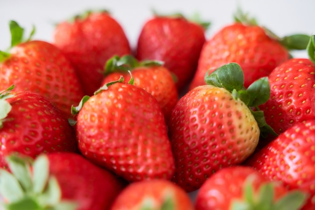 Fresh strawberries on a white plate on a soft wooden base