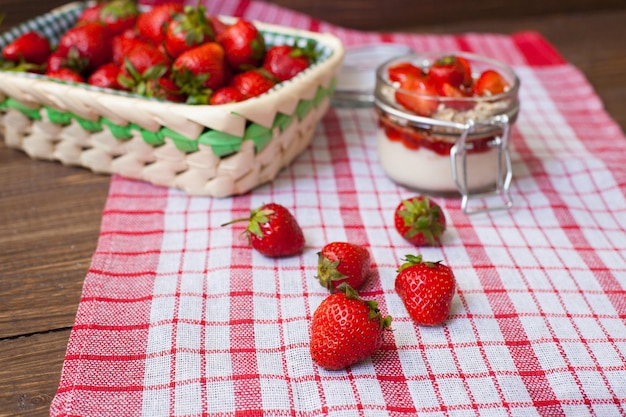 Fresh strawberries with cream and oat flakes in the glass bowl for preparing tasty lunch