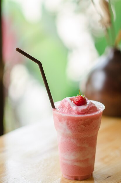 Fresh strawberry smoothie on wooden table