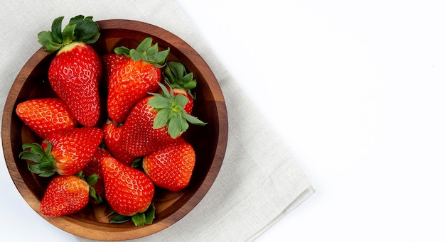 Fresh strawberry in wooden bowl on white background