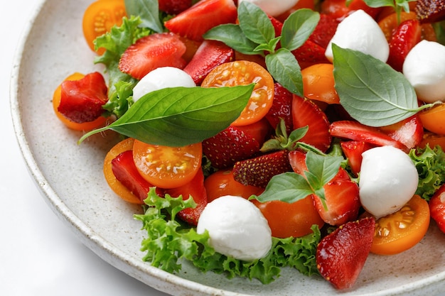 Fresh summer salad with strawberry tomatoes cherry mozzarella cheese and basil Fresh healthy salad