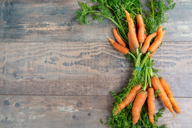 Fresh and sweet carrot on wooden surface