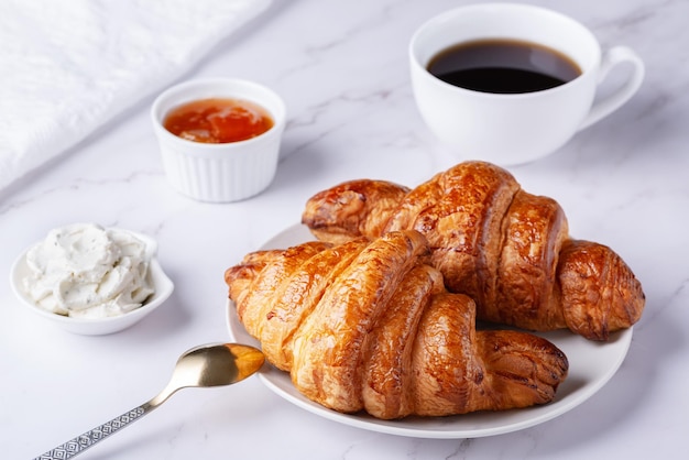 Fresh sweet croissants with cottage cheese and apricot jam for breakfast Continental breakfast