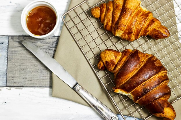 Fresh sweet croissants with orange jam for breakfast Continental breakfast on wood table Top view