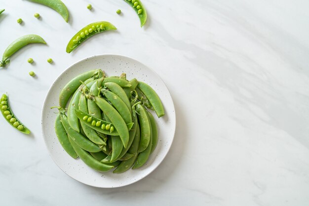 fresh sweet green peas on white plate