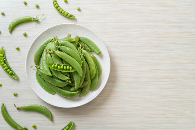 fresh sweet green peas on white plate