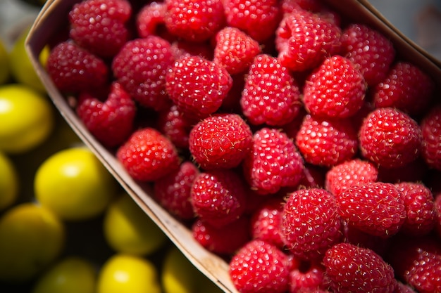 fresh sweet juicy raspberries in a wooden basket with blurred lemons background