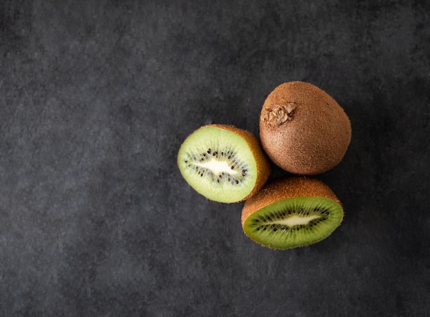 Fresh and sweet kiwi fruits on a dark background The concept of healthy and dietary food Top view copy space