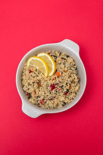 Fresh tabbouleh on small plate on red