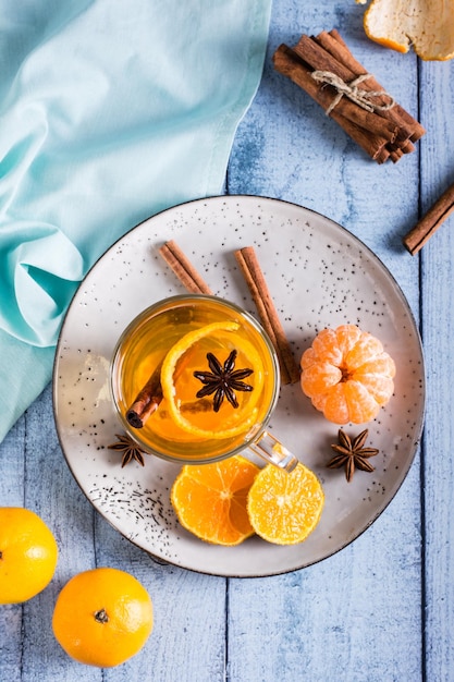 Fresh tangerine tea with cinnamon in a cup on the table Vitamin drink Top and vertical view