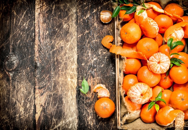 Fresh tangerines on a tray. On a wooden background.