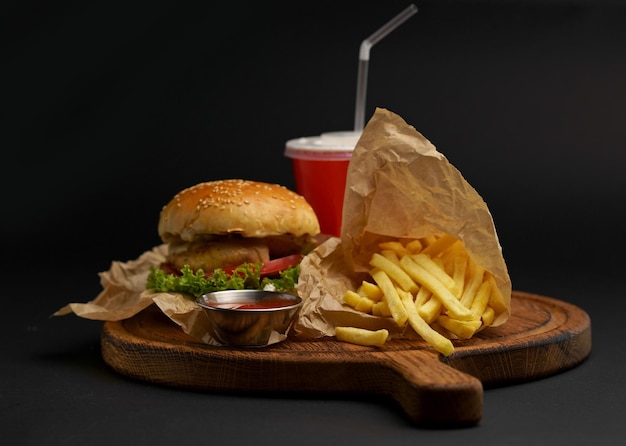 Fresh tasty burger and french fries on wooden table