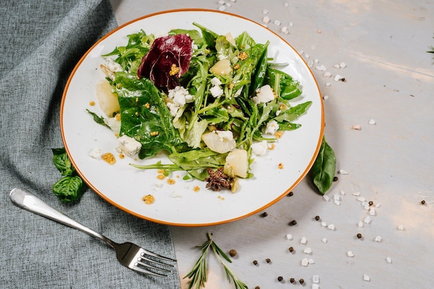 Fresh tasty green salad on the wooden background