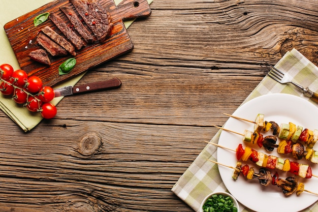 Fresh tasty meat and steak on wooden surface