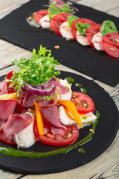 Fresh Tasty Persimmon salad with arugula, parma ham, olive oil and herbs. autumn, winter healthy food