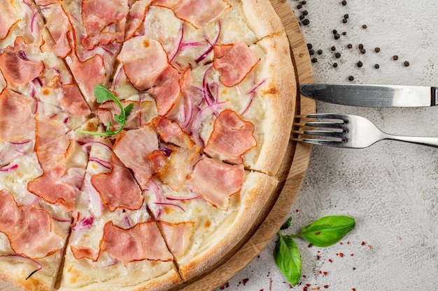 Fresh tasty pizza with meat sausages salamy and ham on white concrete background