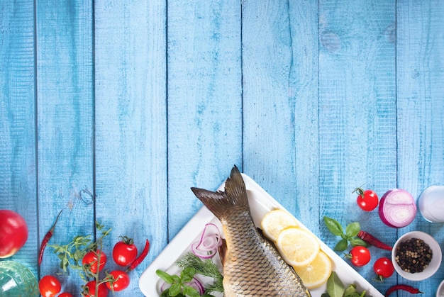 Fresh tasty raw seafood fish served on old blue wooden table with cooking ingredients Top view Copy space