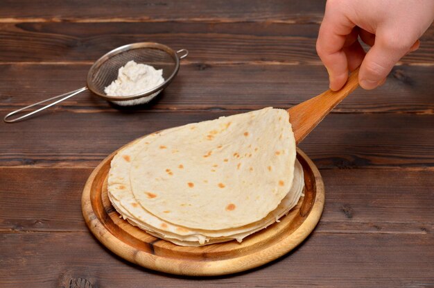 Fresh thin pita breads and a man39s hand with a spatula