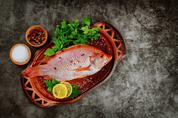 Fresh tilapia with spices and lemon. Top view. Copy space.