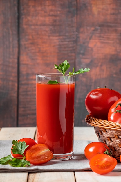 Fresh tomato juice on a wooden rustic background organic vegetable drink with parsley