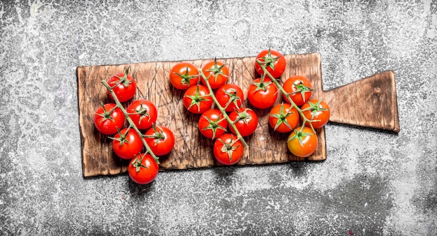 Fresh tomatoes on the old Board. On rustic table.