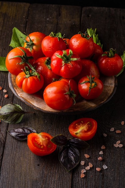 fresh tomatoes in a plate on a dark background harvesting tomatoes