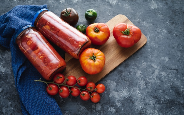 Fresh tomatoes and tomatoes in jars