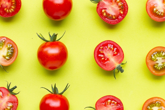 Fresh tomatoes whole and half cut isolated on green background