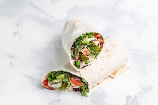 fresh tortilla wraps with vegetables asparagus, avocado, tomatoes, peas, cheese and tartar