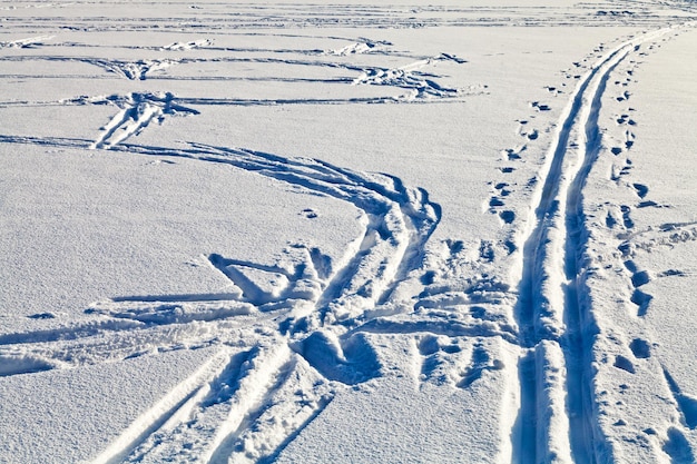 Photo fresh tracks in snowy field in winter day