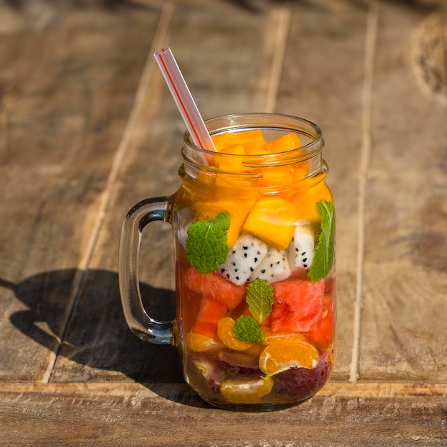 Fresh tropical fruit grapes mango watermelon orange and pitahaya in glass mug healthy breakfast weight loss concept Thailand Close up