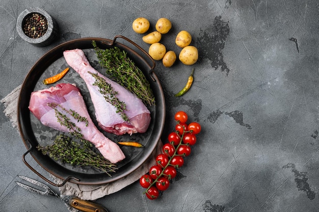 Fresh turkey legs with ingredients for cooking set on gray stone table background top view flat lay with copy space for text