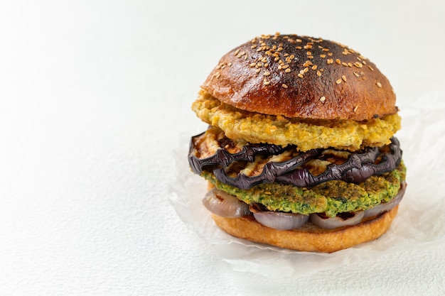 Fresh vegan chickpea burger with onion and grilled eggplant. The concept of healthy and vegetarian food. Place for text.