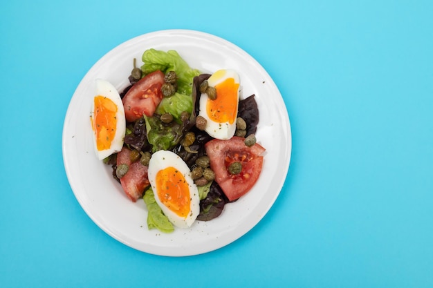 Fresh vegetable salad with boiled egg on white dish