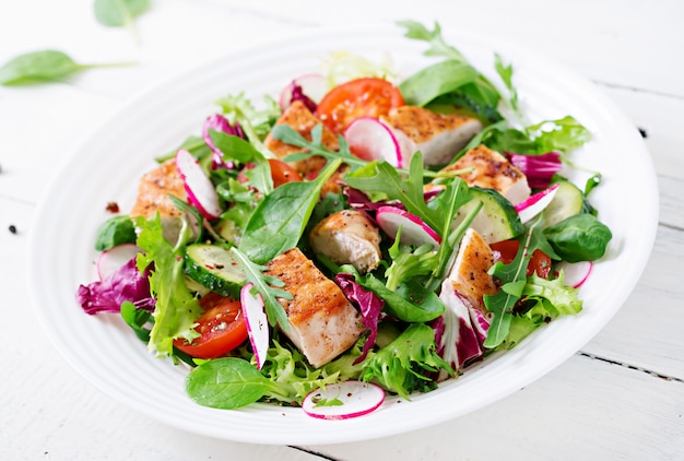 Fresh vegetable salad with grilled chicken breast   - tomatoes, cucumbers, radish and mix lettuce leaves. Chicken salad. Healthy food.