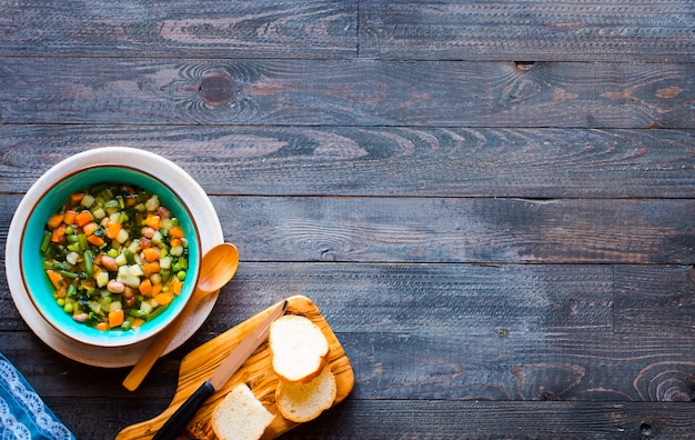 Fresh vegetable soup made at home, on wooden rustic table,  top view