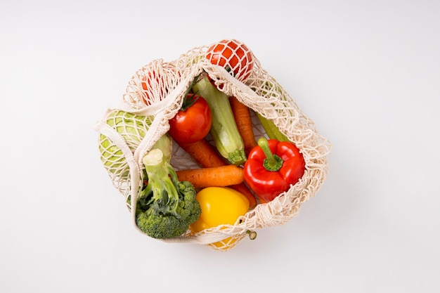 Fresh vegetables in a bag on a white table Top view flat lay Banner