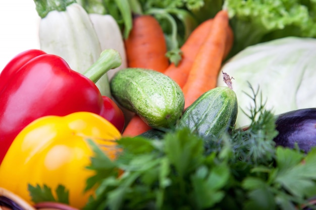 Fresh vegetables in a basket fruit on white