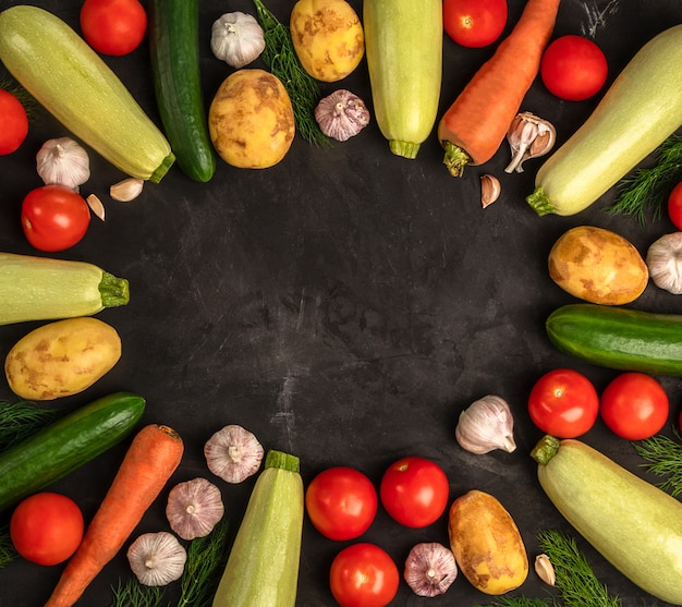 Fresh vegetables on the black background in flat lay design. Vegan concept